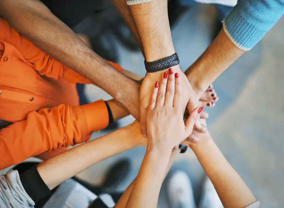 A group of people with their hands together.