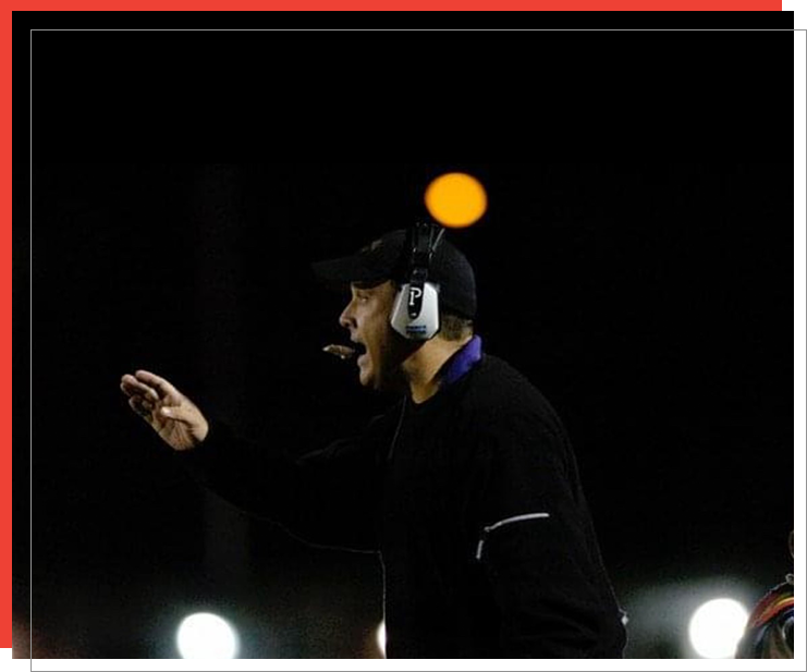 A man in black jacket and headphones on field.