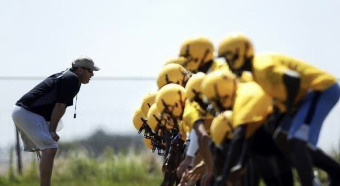 A group of people in yellow helmets standing next to each other.